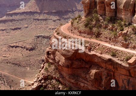 Radtouren am Rand der Klippe - eine Gruppe von Biker sind Reiten auf einer steilen Klippe Straße (Shafer Canyon Trail) im Canyonlands National Park, Moab, Utah, USA. Stockfoto