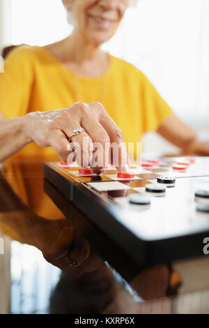 Oma spielen Checkers Board Game in Hospiz Stockfoto
