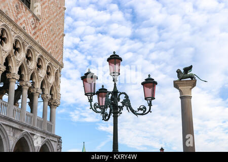 Piazza San Marco in Venedig, Italien, am Tag eines klaren Sommer. Reich verzierte pink Glas streetlight zwischen dem Palazzo Ducale (Dogenpalast) & der Löwe von Venedig. Stockfoto