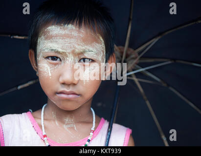 Portrait von kleinen Mädchen mit Gesicht Make-up, Regenschirm, Myanmar Stockfoto