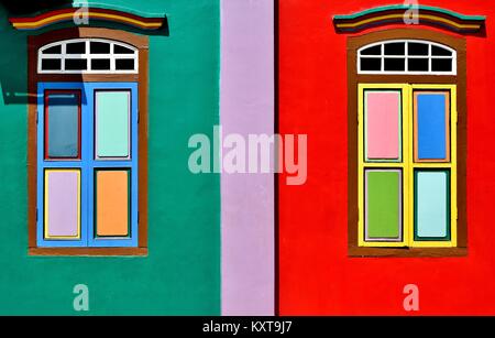 Ein paar farbige Fenster mit Fensterläden aus Holz auf einem traditionellen Haus im historischen Little India, Singapur Stockfoto