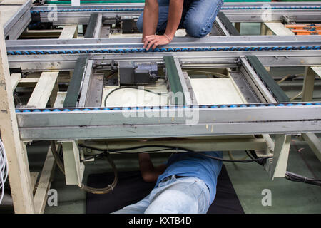 Die Techniker reparieren Transportband in der Factory Stockfoto