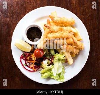 Coconut zerschlagene Garnelen Garnelen mit Pommes und Salat auf einem weißen Teller serviert Stockfoto