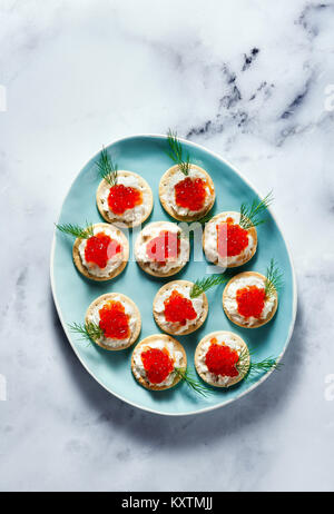 Aperitif des roten Kaviar und Käse mit Dill in einem blauen Platte auf weißem Marmor Stockfoto