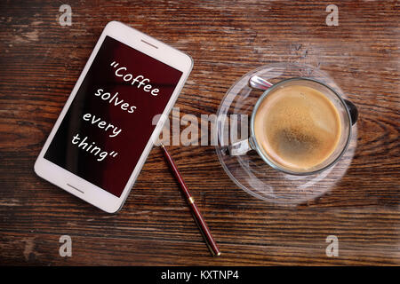 Inspirational motivation Zitat über Kaffee auf Smartphone und die Tasse Kaffee. Stockfoto