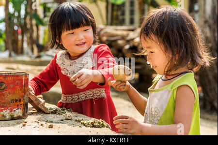 Zwei kleine Mädchen, die außerhalb ihres Hauses, Vietnam Stockfoto