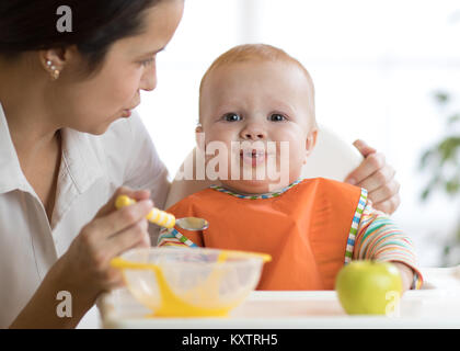 Mutter füttert ihr Kind. Baby weint, launisch und weigert zu essen Stockfoto