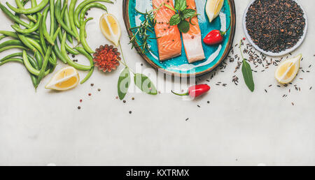 Roher Lachs Steaks mit Gemüse, Reis und Grünen auf Platte Stockfoto