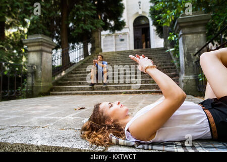 Junges Paar mit Smartphones auf Treppen in der Stadt. Stockfoto