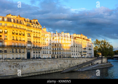 Stürmischer Sommer Abend über Paris mit dem roten Licht der untergehenden Sonne leuchtenden im oberen Teil der Gebäude auf der Insel nennen. Stockfoto