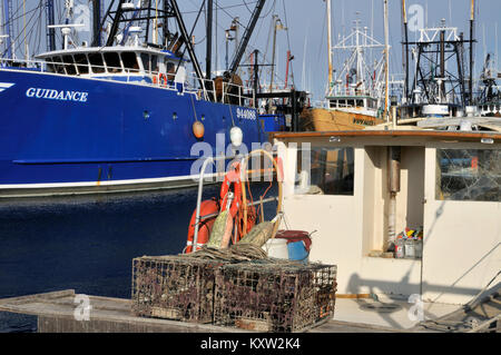 Close-up von Stahl geschält Fischtrawler gebunden im Hintergrund mit Lobster Boat im Vordergrund in New Bedford Hafen zur Wharf, Massachusetts, USA Stockfoto