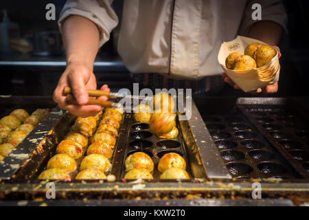 Japanischen Chefkoch kochen takoyaki, tagoyaki ist die beliebteste leckeren Snack in Japan. selektive Fokus und Film Stil Stockfoto