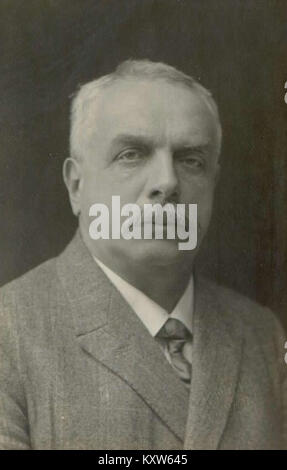 Das Schwarz-weiß-Foto zeigt Fran Jaklic, der Mitte der 1920er Jahre aufgenommen wurde, in dreiteiligem Anzug und Krawatte neben einem Auto der damaligen Zeit steht; das Bild fängt sein formelles Kleid, seine persönliche Haltung und den stilistischen Kontext der Zwischenkriegsdekade ein. Stockfoto