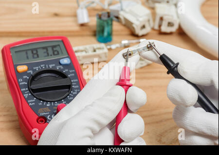 Elektriker mit dem digitalen Multimeter in Werkstatt Stockfoto