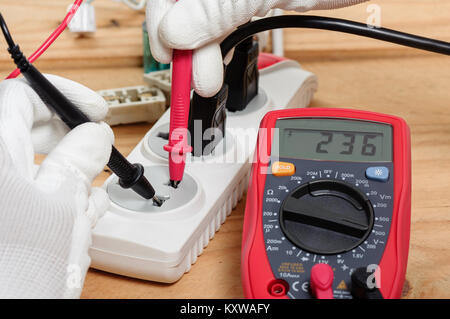 Elektriker mit dem digitalen Multimeter in Werkstatt Stockfoto