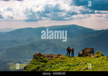 Touristen stehen auf Felsen und die Aussicht genießen. Wunderschöner Blick über die prächtige Polonina Runa Ridge von den Hügeln von Pikui Berg. Lage ukrainischen Carpa Stockfoto