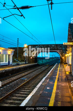 Drem Bahnhof, East Lothian, Schottland, Großbritannien, in der Abenddämmerung mit Licht auf und weg aus Zeichen leuchtet Stockfoto