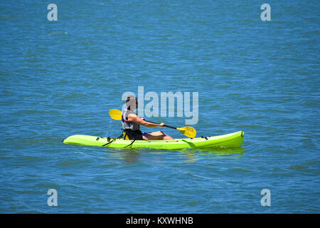 Eine Frau Kajakfahren auf Bellingham Bay im schönen pazifischen Nordwesten. Bellingham, Washington, USA. Boating Center ist auf das Paddel mit einem p geschrieben Stockfoto