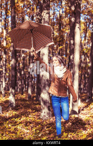 Portrait von aufgeregt wunderschönen Jugendmädchen Holding ein Regenschirm in den Wald Stockfoto