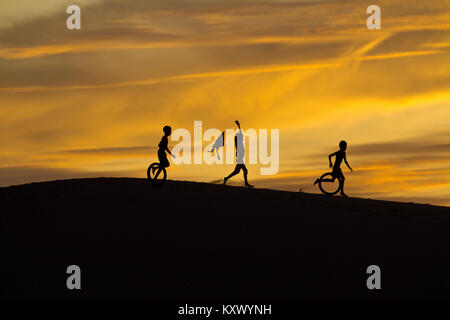 Früh morgens bei Sonnenaufgang - Kinder spielen in den Sanddünen in der Nähe von Phan Rang, central Vietnam Stockfoto