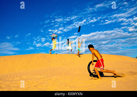 Kinder spielen in den Sanddünen in der Nähe von Phan Rang, central Vietnam Stockfoto