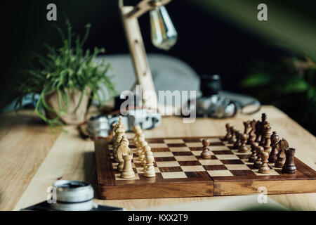 Eine schwarze Bauer bleiben gegen den vollen Satz Schachfiguren am Tisch Stockfoto