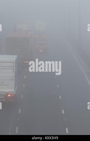 Lastwagen und Autos fahren auf der Autobahn an einem nebligen Tag im Vereinigten Königreich Stockfoto