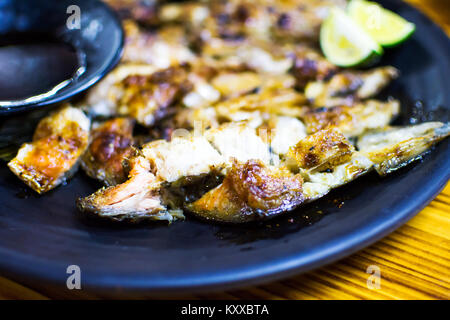 Den gegrillten Lachs Fisch Kopf auf einem Teller, chinesischen Imbiss Stockfoto
