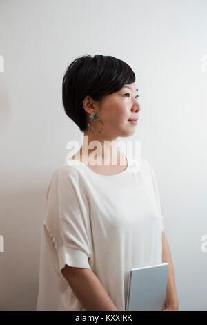 Profil anzeigen von Frau mit Art schwarzes Haar tragen weiße Hemd in der Art Gallery. Stockfoto