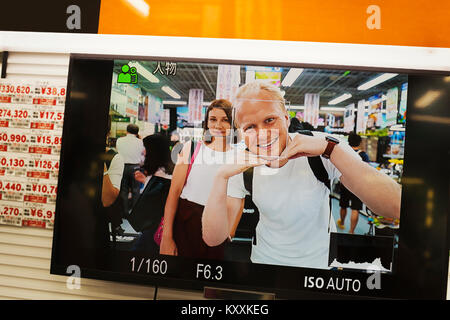 In der Nähe von Bild auf dem Smartphone angezeigt lächelnden Mann und Frau an der Kamera schaut. Stockfoto