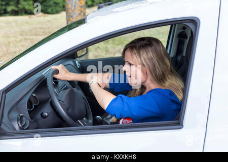 Expressive junge Frau das Auto fahren und sie schaut auf eine Wand zu spät Stockfoto