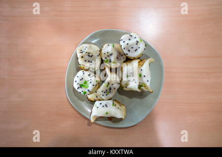 Sheng Jian Bao und Guo Riegel Knödel, Shanghai - style gebratene Knödel auf Holztisch, Overhead Stockfoto