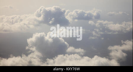 Wolken weiß und grau auf dunklem Hintergrund des blauen Himmels. Luftbild aus dem Flugzeug Fenster Stockfoto