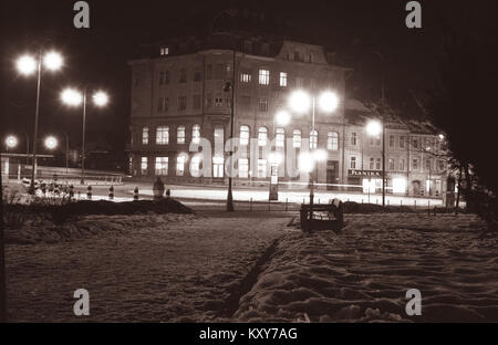 Ein 1956-nächtliches Foto von Glavni trg, dem Hauptplatz von Maribor, Slowenien, zeigt beleuchtete Gebäude, Straßenaktivitäten und städtische Architektur aus der Mitte des 20. Jahrhunderts. Stockfoto