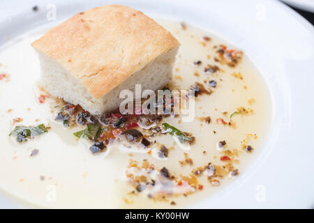 Brot eintauchen in eine erfahrene Olivenöl auf eine weisse Platte Stockfoto