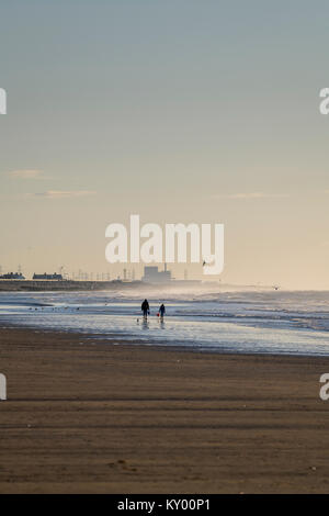 Sturz Strand im Winter Sonnenschein bei Ebbe Blick nach Osten zu Dungeness power station am Horizont. Stockfoto
