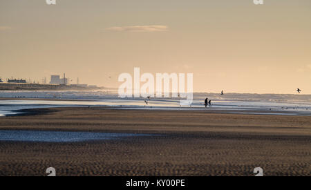 Sturz Strand im Winter Sonnenschein bei Ebbe Blick nach Osten zu Dungeness power station am Horizont. Stockfoto