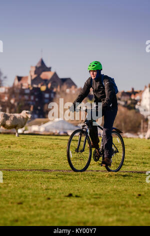 Cyclist with the town of Rye beyond viewed from the south east across fields. Stockfoto