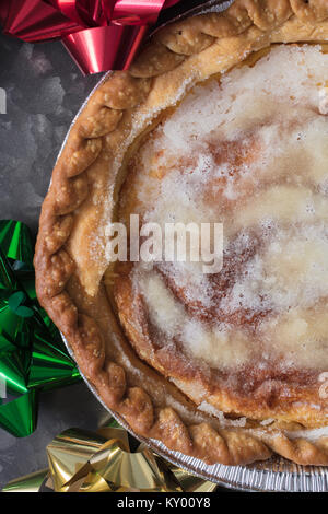 Süße Vanillepudding Karamell Kuchen in der Dose durch Weihnachten Schleifen an einem Metallauflagefach umgeben Stockfoto