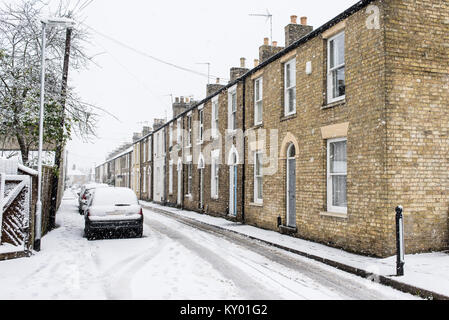 Reihe von restaurierten georgianischen Britischen Stadthäuser in gelben Backsteinen während der schweren Schnee im Winter mit dem Auto auf der Straße geparkt i Stockfoto