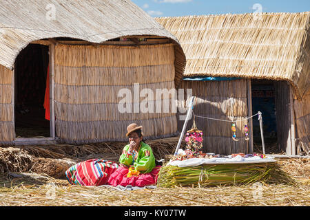 PUNO, PERU - 14. MAI 2015: Nicht identifizierte Frau in traditioneller Kleidung, Kunsthandwerk in der Uros Inseln. Stockfoto