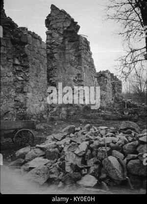 Ein historisches Schwarzweißfoto der Hjälmseryds Old Church in Schweden, erbaut im 12. Jahrhundert. Das Bild zeigt die romanische Steinkonstruktion, den kleinen Turm und die ländliche Umgebung, die mittelalterliche schwedische Kirchenarchitektur darstellt. Stockfoto