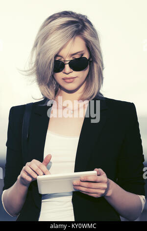 Young Fashion Business Woman in Sonnenbrille mit Tablet-PC in der Stadt. Stockfoto