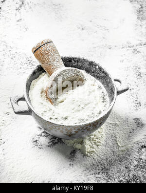 Mehl mit einer Kugel in eine Schüssel geben. Auf dem Tisch aus Stein. Stockfoto