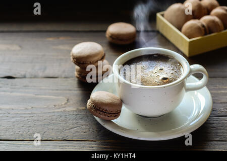 Schokolade Kakao französische Kekse macarons mit Kaffee. Von Tasse Dampf Stockfoto