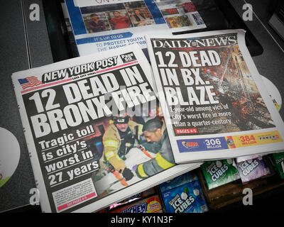 Schlagzeilen der New York Daily News und der New York Post haben identische Schlagzeilen am Freitag, 29 Dezember, 2017 Editionen die Berichterstattung über den Tod von 12 Im schlimmsten Feuer die Stadt in 27 Jahren gesehen hat. (© Richard B. Levine) Stockfoto