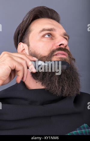 Nahaufnahme der Friseur kämmen Bart eines jungen gutaussehenden Mann. Studio shot Stockfoto