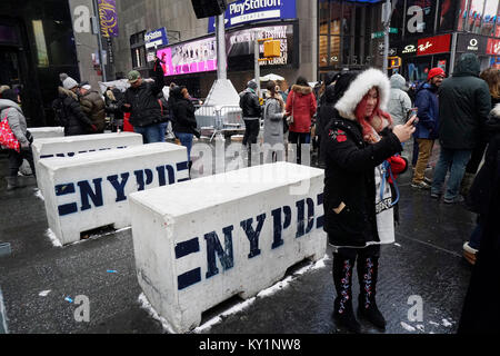 Touristen durch Barrikaden an den Perimeter des Times Square in New York am Samstag, 30. Dezember 2017. Sicherheit die Vorbereitungen für Silvester am Times Square einschließlich der Platzierung der Dachterrasse Beobachtungen Teams und NYPD Scharfschützen. Das Wetter für Silvester wird voraussichtlich im niedrigen Teens als viele stand außerhalb für Stunden warten auf den Times Square Ball Drop. (© Richard B. Levine) Stockfoto