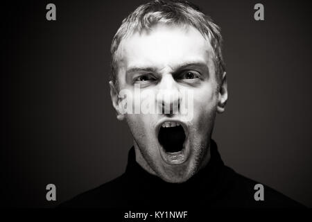 Verärgert man schreien. Ein Mann in einem schwarzen T-Shirt. Stockfoto
