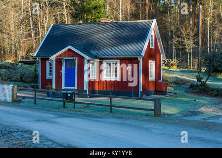 Ronneby, Schweden - 7. Januar 2018: Dokumentarfilm von Alltag und Umwelt. Traditionelles rotes Holz im Wald. Land straße und letterbo Stockfoto